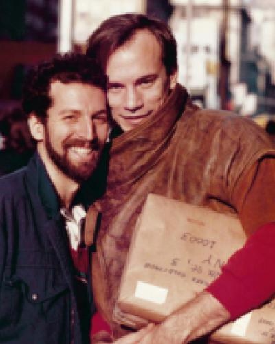 In an image from the exhibit, Mark Goldstaub and Edmund Wojcik pose for an impromptu photo on a New York City sidewalk. The leather jacket in the image is on display as part of the exhibit. 